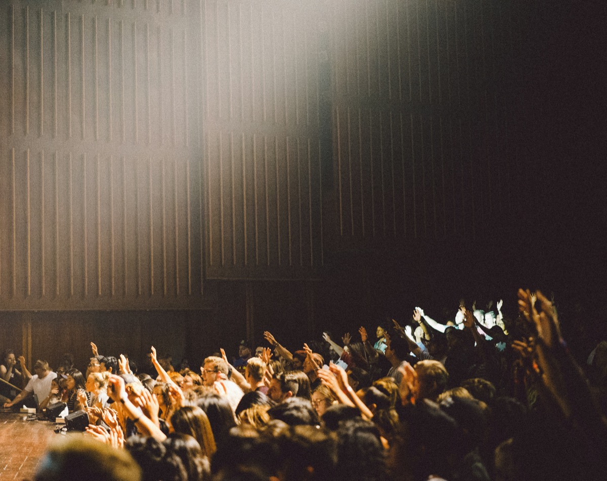 An audience in a lecture auditorium, from the supplied brand reference.
